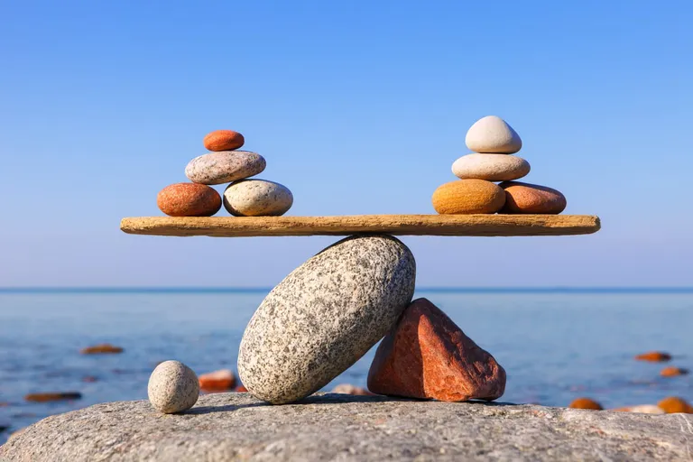 Symbolic scales of the stones against the sea. pros and cons concept
